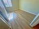 A view of a bedroom with light walls, light wood flooring, and a window at 1630 Meadow Bluffs Ave, Henderson, NV 89014