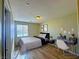 Comfortable bedroom with a sleek bed, wooden floors, and a dedicated workspace perfect for relaxation and productivity at 1630 Meadow Bluffs Ave, Henderson, NV 89014