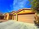 Spacious three-car garage with concrete driveway and desert landscaping around the house at 1630 Meadow Bluffs Ave, Henderson, NV 89014