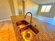 Close-up of a kitchen island with a double sink and granite countertops at 1630 Meadow Bluffs Ave, Henderson, NV 89014