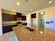 Well-lit kitchen features granite island, dark wood cabinets, and stainless steel appliances at 1630 Meadow Bluffs Ave, Henderson, NV 89014