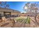 Back yard with artificial turf, gravel landscaping, mature shade trees, patio, and desert landscaping at 258 Spring River Ave, Las Vegas, NV 89123