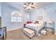 A bright bedroom with a ceiling fan, carpet, and unique window is featured at 258 Spring River Ave, Las Vegas, NV 89123