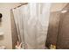 Full view of shower with textured walls and grey, white and black patterned shower curtain at 2606 S Durango Dr # 152, Las Vegas, NV 89117