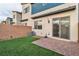 View of home's back exterior highlighting sliding glass doors leading to brick-paved patio and turf at 2699 Chance Canyon St, Henderson, NV 89044