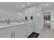 Bright bathroom featuring double vanity, quartz countertop, and a view into the walk-in closet at 2699 Chance Canyon St, Henderson, NV 89044