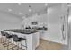 Modern kitchen with sleek white cabinetry, black countertops, stainless steel appliances, and a stylish breakfast bar at 2699 Chance Canyon St, Henderson, NV 89044