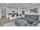 Open concept living room with kitchen island, gray sectional sofa, and modern decor at 2699 Chance Canyon St, Henderson, NV 89044