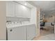 Functional laundry room with a side-by-side washer and dryer and built-in upper cabinets at 3111 Bel Air Dr # 20D, Las Vegas, NV 89109