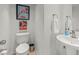 Well-lit powder room featuring vintage wall art, a modern toilet, and a sleek pedestal sink at 3111 Bel Air Dr # 20D, Las Vegas, NV 89109