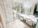 Elegant bathroom with marble tiling, dual sinks, and a glass-enclosed shower featuring a rainfall showerhead at 4381 W Flamingo Rd # 2109, Las Vegas, NV 89103