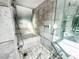 Luxurious bathroom featuring a soaking tub, a glass-enclosed shower, and elegant marble tile at 4381 W Flamingo Rd # 2109, Las Vegas, NV 89103
