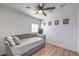 Light, bright bedroom with wood-look floors, ceiling fan, and gray daybed with decorative art at 500 Duchess Ave, North Las Vegas, NV 89030