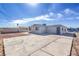 Single story home with desert landscaping and long driveway leading to a blue door at 500 Duchess Ave, North Las Vegas, NV 89030