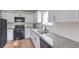 Modern kitchen with white cabinets, granite counters, subway tile backsplash, and black appliances at 500 Duchess Ave, North Las Vegas, NV 89030