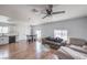 Open-concept living room features wood floors, sofas, ceiling fan and kitchen area at 500 Duchess Ave, North Las Vegas, NV 89030