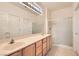 Bathroom with double sinks, tile floor, and a glass enclosed shower at 538 Cypress Gardens Pl, Henderson, NV 89012