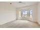 Empty bedroom features a ceiling fan, neutral carpet, and a large window with a neighborhood view at 538 Cypress Gardens Pl, Henderson, NV 89012