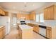 Bright kitchen features an island, tile floors, light wood cabinets, and white appliances at 538 Cypress Gardens Pl, Henderson, NV 89012
