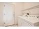 Functional laundry room with a washer and dryer, shelving, and access door at 538 Cypress Gardens Pl, Henderson, NV 89012