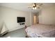Large primary bedroom featuring a ceiling fan and a large screen television at 6437 Boatbill St, North Las Vegas, NV 89084