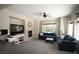 Spacious living room with a fireplace, large windows, and plush seating, perfect for relaxation and entertaining at 6437 Boatbill St, North Las Vegas, NV 89084