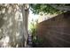 A narrow side yard with rock features and foliage for added privacy at 6437 Boatbill St, North Las Vegas, NV 89084