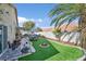 A backyard featuring artificial turf, desert landscaping, an exercise area and various seating areas at 688 Quiet Stream Ct, Henderson, NV 89052
