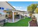Backyard featuring artificial turf, a covered patio, desert landscaping and various seating areas at 688 Quiet Stream Ct, Henderson, NV 89052