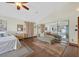 Bright bedroom featuring wood floors, a sitting area, and a full-length mirrored closet at 688 Quiet Stream Ct, Henderson, NV 89052