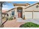 Inviting home exterior featuring a red front door, attached garage, and well-kept landscaping at 688 Quiet Stream Ct, Henderson, NV 89052