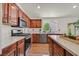 Bright kitchen featuring granite countertops, tile floors, wood cabinets, and stainless steel appliances at 688 Quiet Stream Ct, Henderson, NV 89052