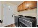 Convenient laundry area with a washer, dryer, storage cabinets, and a nearby entry door at 688 Quiet Stream Ct, Henderson, NV 89052