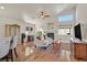 Open-concept living room with vaulted ceiling, fireplace, ceiling fan, wood look tile floors and neutral decor at 688 Quiet Stream Ct, Henderson, NV 89052
