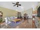 Open-concept living and dining area with wood-look floors, ceiling fan, and plenty of natural light at 688 Quiet Stream Ct, Henderson, NV 89052