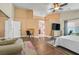 Spacious main bedroom with hardwood floors, ceiling fan, television, and sitting area at 688 Quiet Stream Ct, Henderson, NV 89052