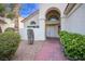 The front entrance of the home with an arched doorway and desert landscaping at 726 Sea Pines Ln, Las Vegas, NV 89107