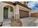The front entrance to the house features a arched doorway and a two car garage at 7530 Brisa Del Mar Ave, Las Vegas, NV 89179