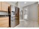 Stylish kitchen boasts stainless steel refrigerator, wood cabinets, and a seamless transition to the living area at 7530 Brisa Del Mar Ave, Las Vegas, NV 89179