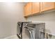 Laundry room with tile floors, cabinetry, and modern washer and dryer at 7530 Brisa Del Mar Ave, Las Vegas, NV 89179