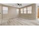 Bright room featuring light wood floors, multiple windows, neutral paint, and a ceiling fan at 7530 Brisa Del Mar Ave, Las Vegas, NV 89179