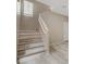 Light-filled staircase features wood-style steps and sleek white railings, enhancing the home's modern aesthetic at 7530 Brisa Del Mar Ave, Las Vegas, NV 89179