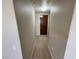 Narrow hallway with neutral carpet leading to a dark wooden door at 8255 Las Vegas Blvd # 711, Las Vegas, NV 89123