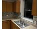 A kitchen sink and counter top area with modern stone back splash and amazing nighttime views at 8255 Las Vegas Blvd # 711, Las Vegas, NV 89123