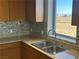 A kitchen sink and counter top area with modern stone back splash and amazing daytime views at 8255 Las Vegas Blvd # 711, Las Vegas, NV 89123