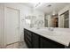 Bright bathroom featuring a double sink vanity with black cabinets, large mirror, and white counter tops at 841 Glitter Glen Ct, Las Vegas, NV 89123