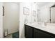 Bathroom features a dark vanity with a white sink and decorative wall art at 841 Glitter Glen Ct, Las Vegas, NV 89123