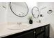 Stylish bathroom featuring dual sinks, modern fixtures, black vanity, and round mirrors at 841 Glitter Glen Ct, Las Vegas, NV 89123