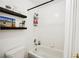 Bright bathroom featuring a shower-tub combination and floating wooden shelves with decorative accents at 841 Glitter Glen Ct, Las Vegas, NV 89123