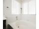 Bright bathroom featuring a white tiled alcove bathtub, and a window with light streaming through the blinds at 841 Glitter Glen Ct, Las Vegas, NV 89123